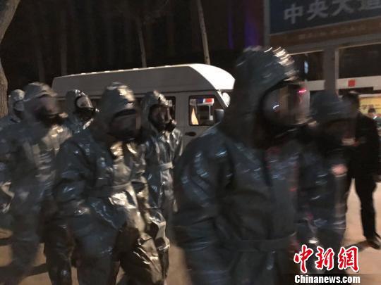 十几名身着防护服的人员头戴面具进入事发地。　胡健 摄